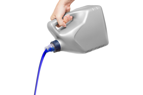 Синя моторна олія, що виливається з каністри в руці ізольовано на білому
 - Фото, зображення