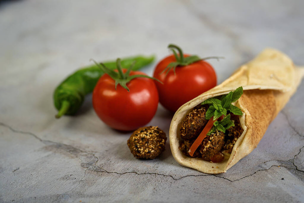 Falafel-voileipä kasvisruokaa kääreessä tasainen arabialainen leipä. - Valokuva, kuva