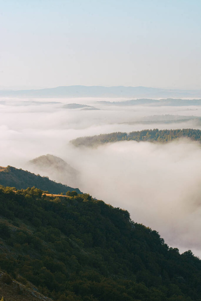 Um tiro vertical de nuvens flutuantes sobre falésias rurais - Foto, Imagem