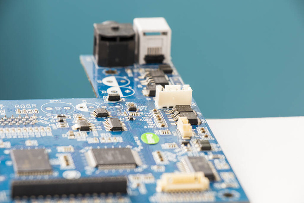 A closeup of a blue electronic circuit board - Fotó, kép
