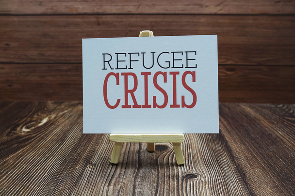 Refugee Crisis text on paper card on wooden background - Foto, imagen