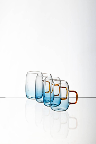 The vertical shot of a glass blue transparent  cups with a white background - Foto, Imagem