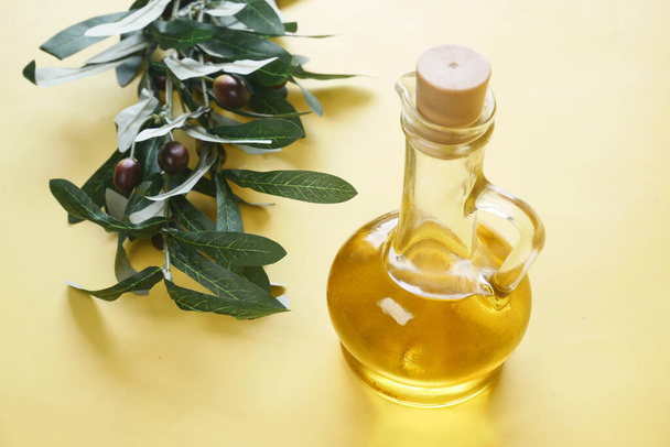 bouteille d'huile d'olive et d'olive fraîche dans un récipient sur la table - Photo, image