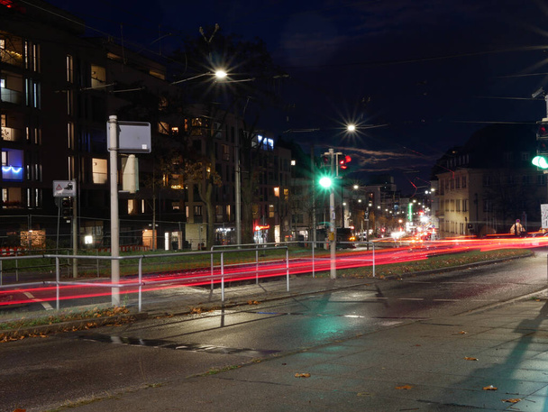A long exposure shot of the street, buildings and lights of the city at night in Germany - Zdjęcie, obraz