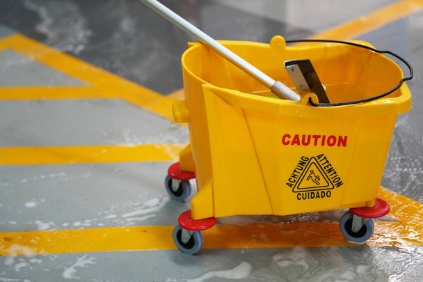 Yellow mop bucket and set of cleaning equipment in the office - Foto, imagen