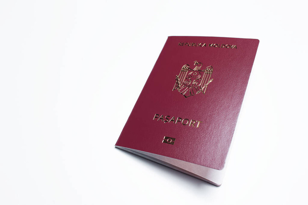 Nahaufnahme des moldawischen Passes von roter Farbe auf weißem Hintergrund. - Foto, Bild