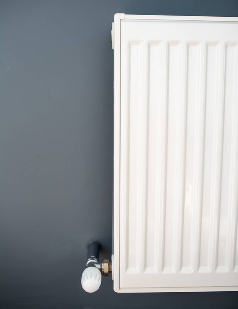 Gros plan du radiateur de chauffage en acier blanc sur un mur gris. - Photo, image