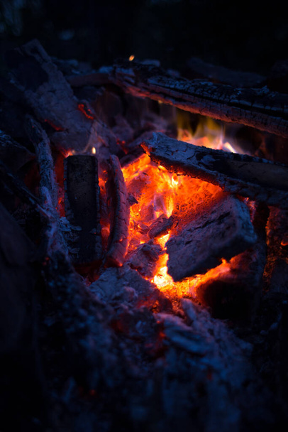 A vertical closeup shot of burning coals in a fireplace - Zdjęcie, obraz