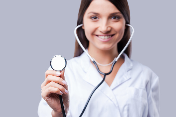 Doctor in white uniform holding stethoscope - Fotó, kép