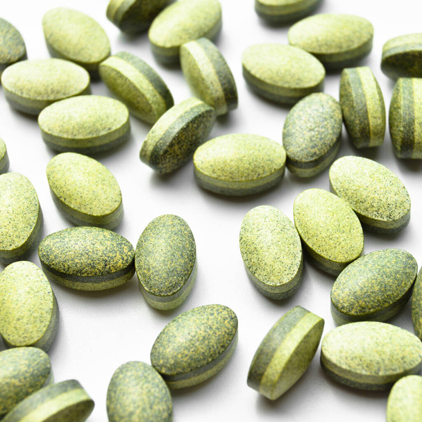 Groene ovale tablet pillen geïsoleerd op witte achtergrond, medische ovale pillen tabletten - Foto, afbeelding