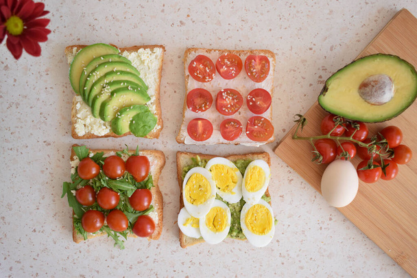Brindisi sano per la prima colazione con avocado, uova, pomodori, rucola ecc. - Foto, immagini