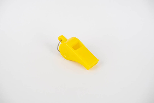 A close-up shot of a yellow whistle isolated on a white background - Foto, imagen