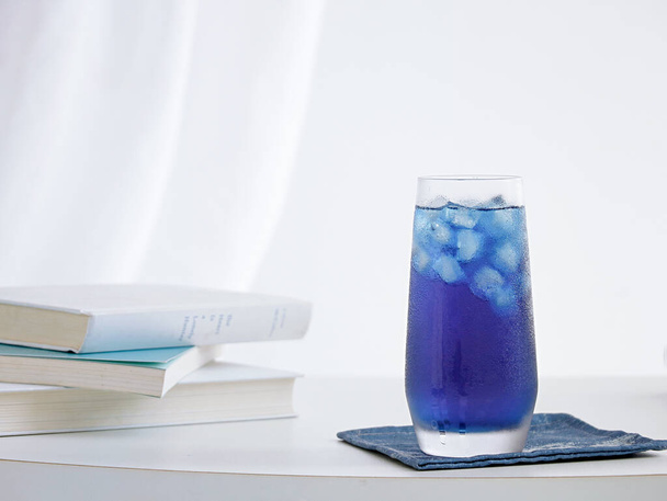 A selective focus shot of blue cocktail with ice cubes on a table - Foto, Imagen