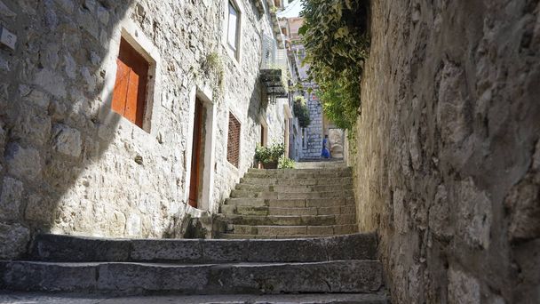 A shot of stone stairs going up to a backyard against old houses in Dubrovnik, Croatia - 写真・画像