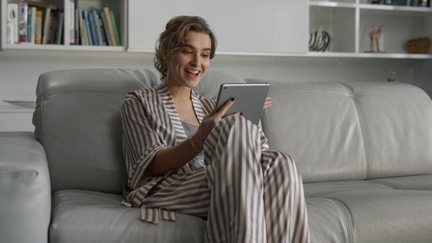Cheerful girl making video call at home interior. Smiling lady waving at tablet. Happy beautiful woman blogger enjoy talking online recording vlog. Attractive businesswoman work at remote workplace - Photo, Image
