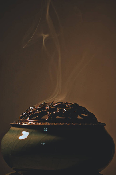 A vertical shot of smoke coming out of a censer on a blurred background - Фото, изображение