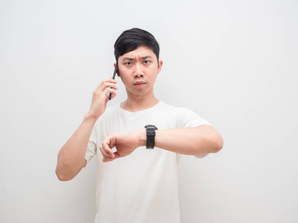 Asian man holding cellphone show his watch up serious face businessman concept - Фото, зображення