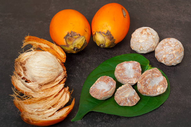 Fresh betel nut or areca nut with betel leaf isolated on dark background. - Photo, Image