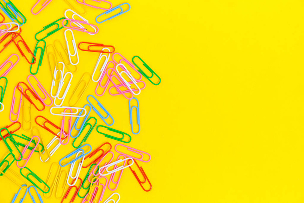 Colored paper clips on a yellow background - Fotó, kép