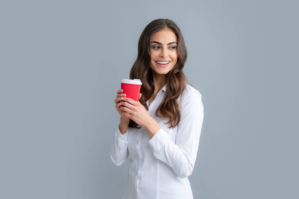 Beautiful young woman enjoying a cup of coffee while relaxing. People, drinks and leisure break, happy young woman with cup of tea or coffee - Photo, Image