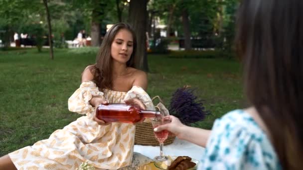 девушка в синем платье в парке на пикнике на отдыхе пьет вино - Кадры, видео