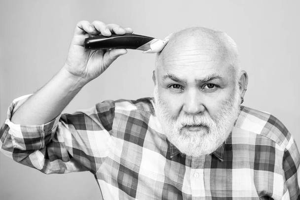 Bald man hairclipper, Mature baldness and hair loss concept. Middle aged gray man - 写真・画像