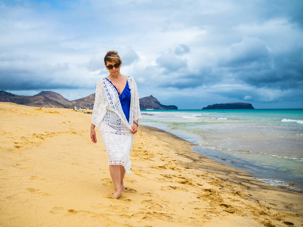Mujer de mediana edad caminando en la playa  - Foto, imagen