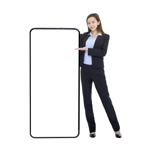 Geschäftsfrau stützt sich auf riesiges Handy mit weißem Bildschirm und empfiehlt großartige neue App oder Website für Smartphones - Foto, Bild
