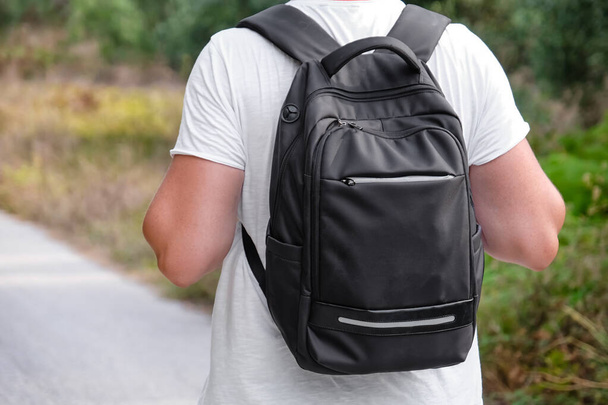 Młody mężczyzna podróżnik z nowoczesnym plecakiem na zewnątrz, widok z tyłu - Zdjęcie, obraz