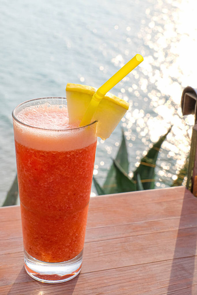 Szklanka świeżego tropikalnego koktajlu na stole w kurorcie morskim - Zdjęcie, obraz