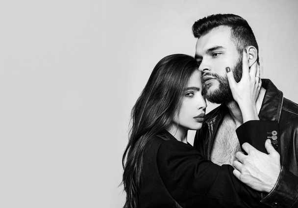 Touch his bristle. Passionate hug. Passionate couple in love. Man brutal well groomed macho and attractive girl cuddling. Girlfriend passionate red lips and man leather jacket. She adores male beard. - Fotó, kép