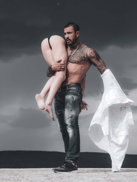 Latino handsome man and sexy woman. Man is carrying his woman. Love. Couple. Passion - Φωτογραφία, εικόνα