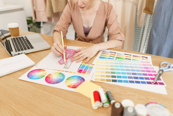 Fashion design concept, Asian female fashion designer choose color and drawing new dress collection. - Photo, image