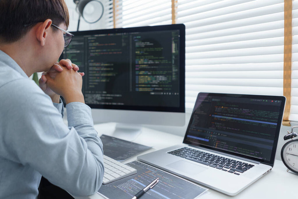 Softwareentwicklungskonzept, männliche Programmierer lesen Datencode zu nachdenklich über die Entwicklung von Website. - Foto, Bild
