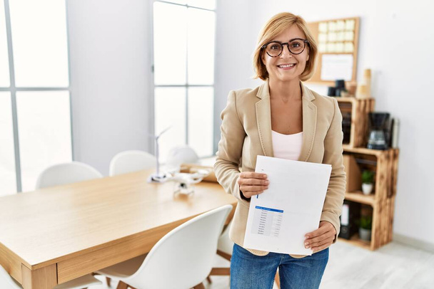 Middle age blonde woman smiling confident working at architecture studio - Photo, Image