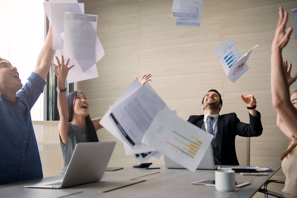 business people celebrating by throwing documents after working success in office - Fotoğraf, Görsel