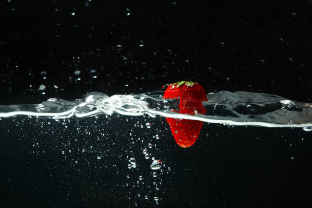 Έννοια της φρεσκάδας, φρέσκια φράουλα ενάντια στο σκοτάδι - Φωτογραφία, εικόνα