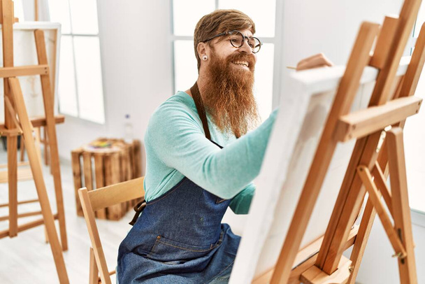 Junger Rotschopf lächelt selbstbewusst Zeichnung im Kunstatelier - Foto, Bild