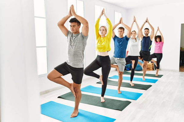 Gruppo di giovani concentrato yoga di formazione presso il centro sportivo. - Foto, immagini