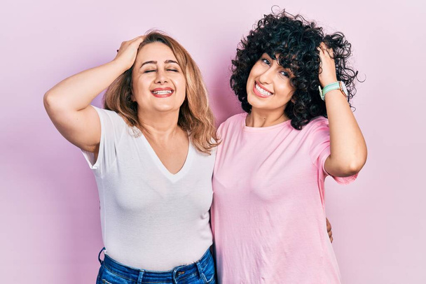 Middle east mother and daughter wearing casual clothes smiling confident touching hair with hand up gesture, posing attractive and fashionable  - Photo, Image