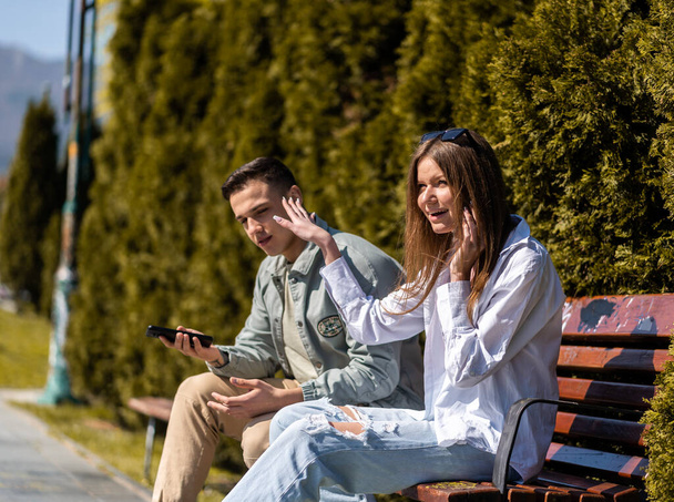 Dwóch przyjaciół happy nastolatka rozmawia i spojrzenie w parku - Zdjęcie, obraz