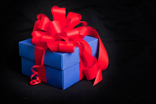 голубая подарочная коробка с красной лентой и луком
 - Фото, изображение