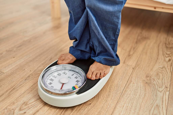 Middle age caucasian woman using weighing machine at home - Photo, Image
