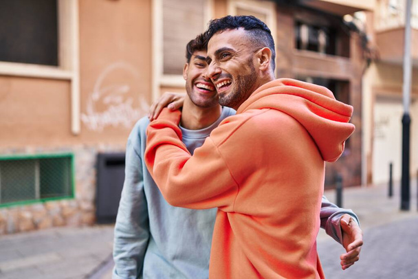 Δύο αντρικά ζευγάρια αγκαλιάζονται όρθιοι στο δρόμο - Φωτογραφία, εικόνα