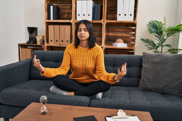 Jonge Latijnse vrouw psychologie patiënt ontspannen doen yoga oefening in de kliniek - Foto, afbeelding