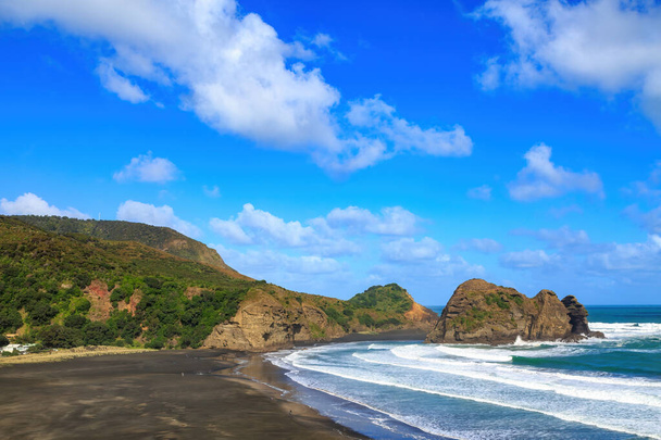 The black sand beach at Piha, New Zealand. In the sea just offshore are Taitomo Island and Nun Rock  - Fotó, kép