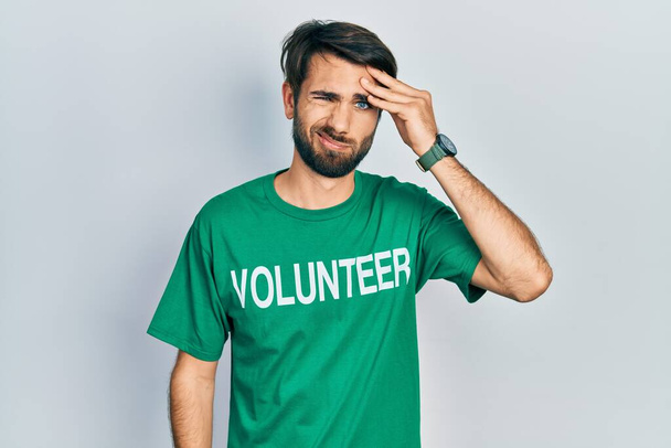 Молодий іспаномовний чоловік у волонтерській сорочці хвилювався і підкреслював проблему з рукою на лобі, нервував і турбувався про кризу
  - Фото, зображення