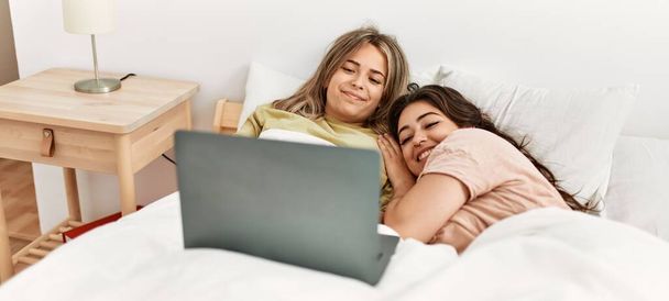 Genç çift yatak odasında dizüstü bilgisayar kullanarak film izliyor. - Fotoğraf, Görsel
