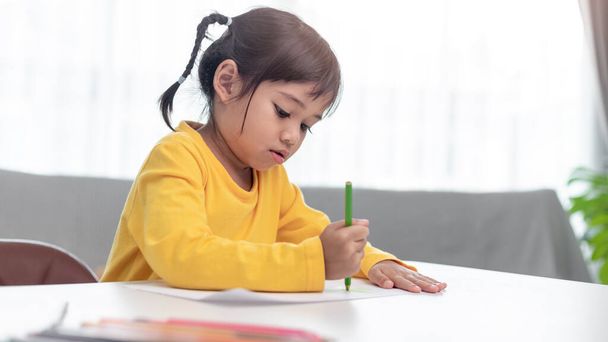 Азиатский малыш, выполняющий домашнюю работу. - Фото, изображение
