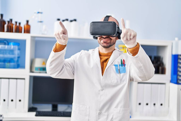 Jonge man wetenschapper met behulp van virtual reality bril in het laboratorium - Foto, afbeelding